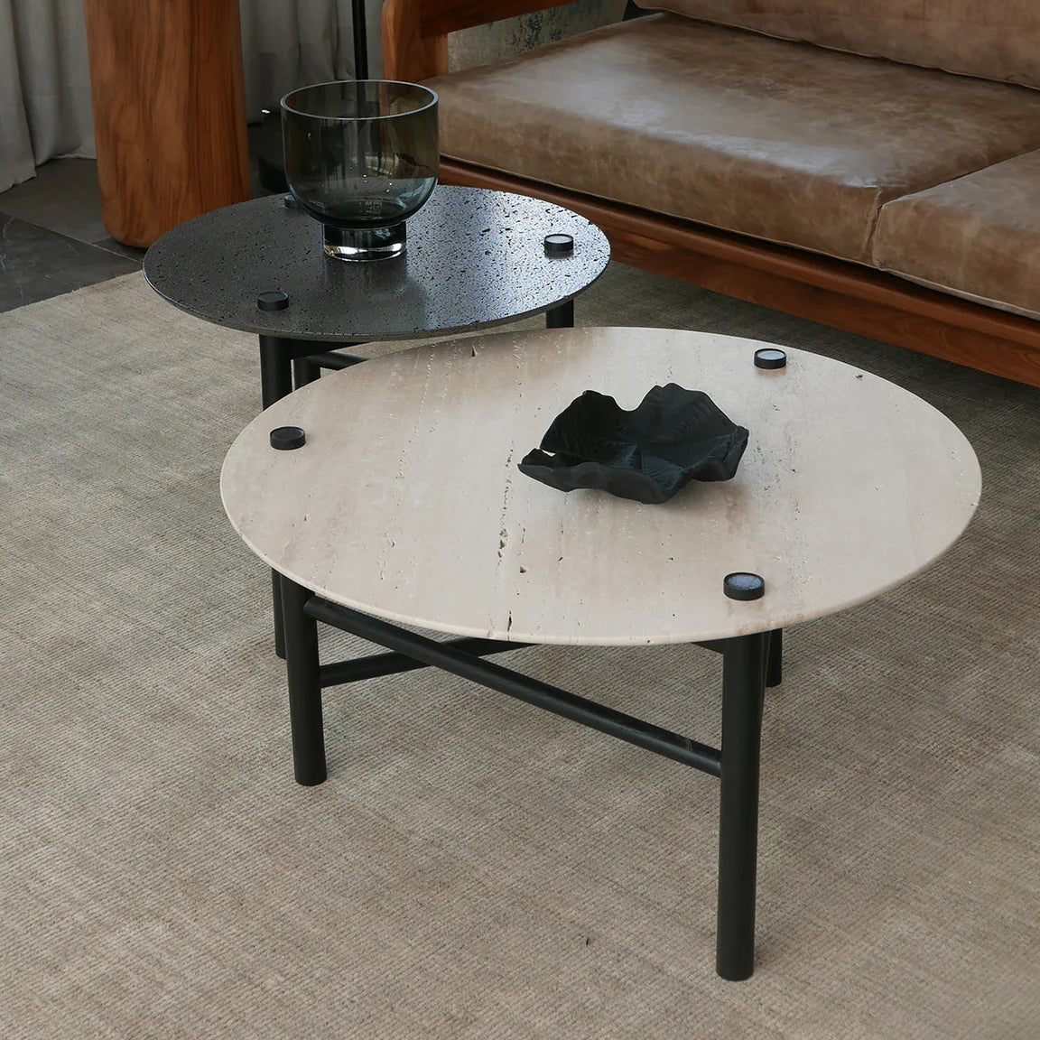 Round coffee table with black legs in a living room setting