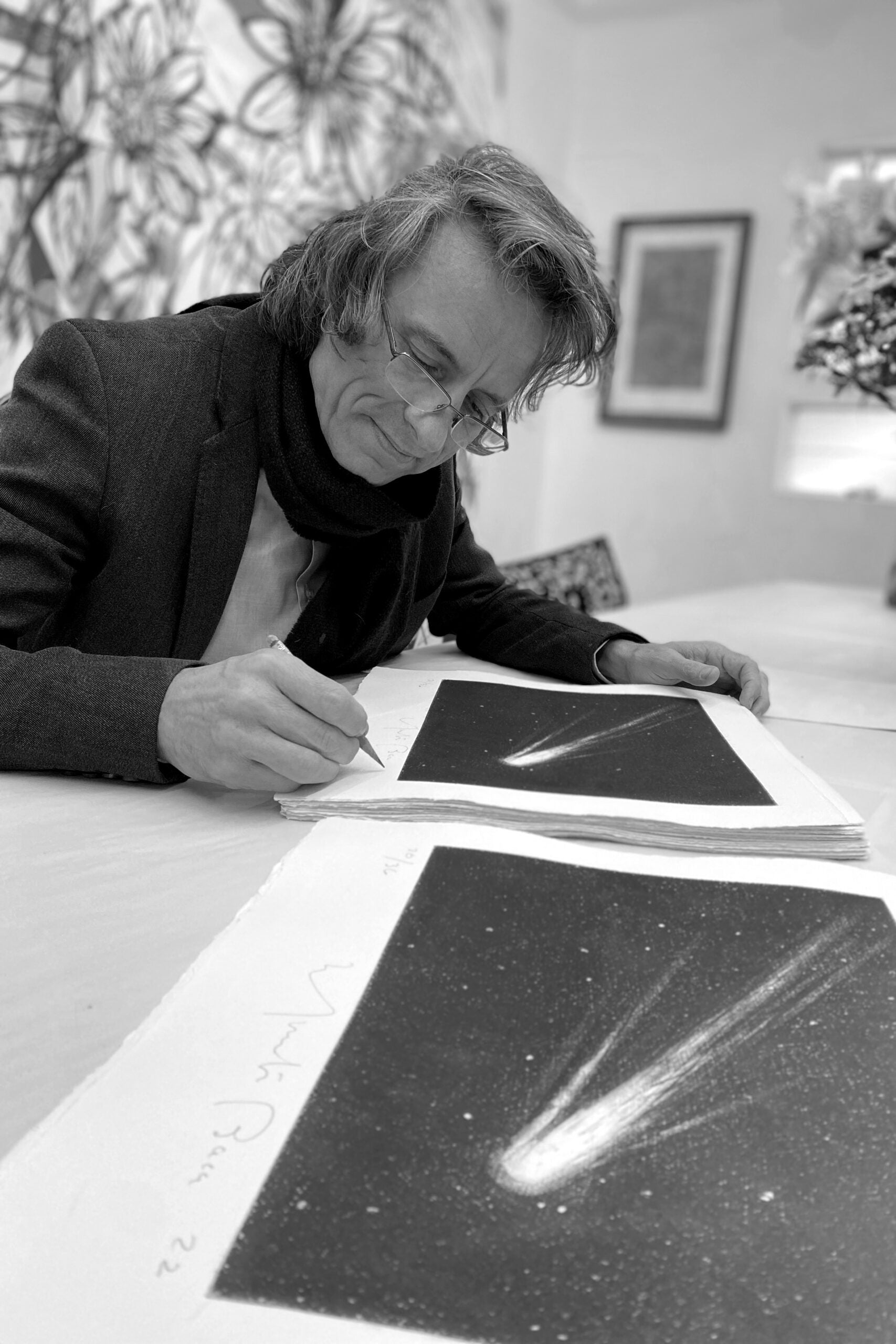 Person examining photographs of comets on a table