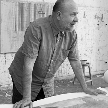 Man working on a large sheet of paper in an office setting