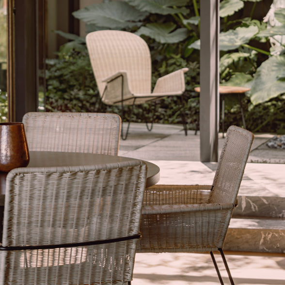 Outdoor patio setting with wicker chairs and a table on a wooden deck.